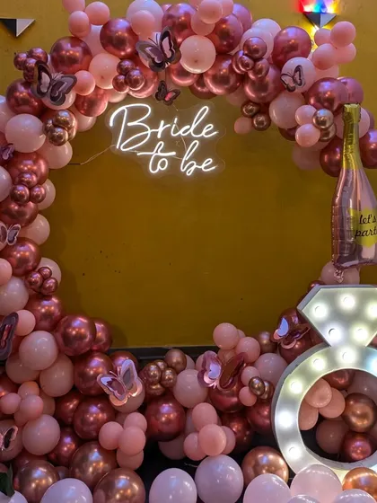 A closer look at the rose gold balloon arch, showing the details of the metallic and pastel balloons and the pretty butterfly accents.