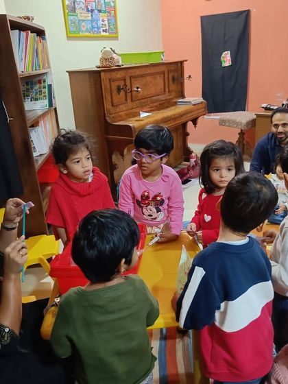 Children gather around a table for a Christmas craft, their faces full of excitement and anticipation.
