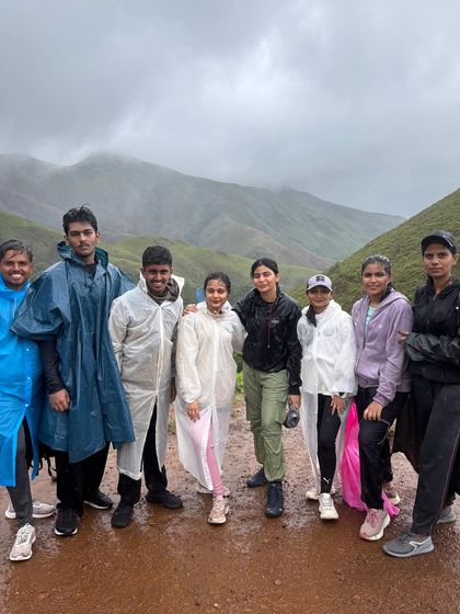 A group of trekkers in their rain gear, all smiles despite the rain on the Kudremukha trail.