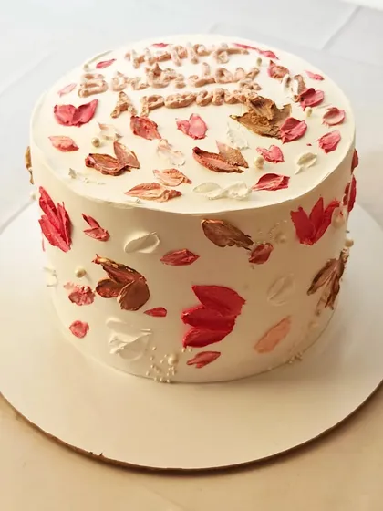 A cake decorated with autumn-colored leaves created with a palette-knife technique. The warm tones of red, orange, and brown give this cake a cozy, seasonal feel.