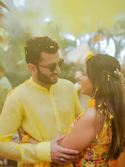 A candid, romantic moment during the haldi. The flower petals in the air add a touch of magic to their embrace.