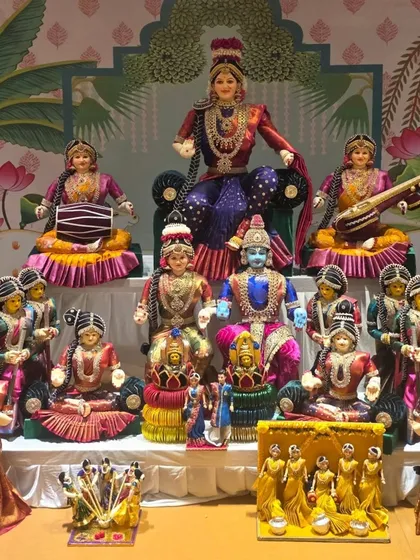 Another beautiful Golu display featuring traditionally dressed dolls, set against a painted backdrop.