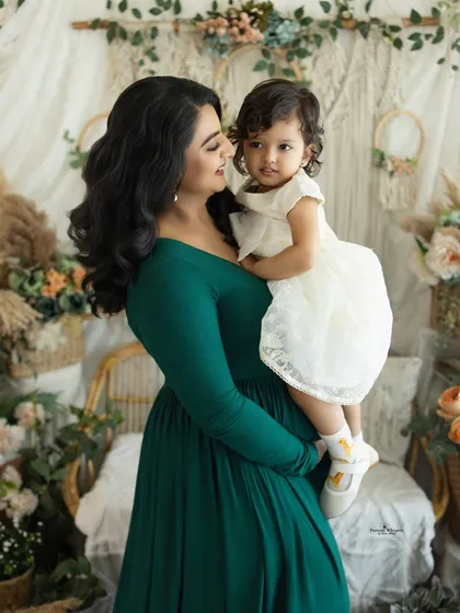 A beautiful moment between a mother and her daughter. This portrait captures their loving gaze against a soft, bohemian backdrop, celebrating their special bond as the family prepares to grow.