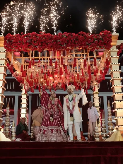 For this destination wedding in Rajasthan, we created a royal Varmala ceremony. The couple stood on a grand stage with a custom red floral mandap, complete with dramatic fireworks that lit up the palace backdrop.