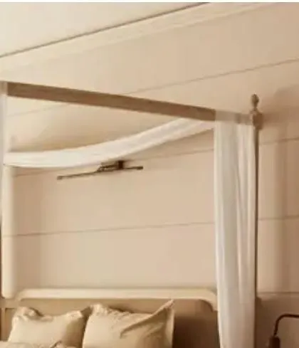Another view of the canopy bed, highlighting the clean lines of the headboard and the warm, neutral wall paneling. The design is a perfect example of understated elegance and timeless appeal.