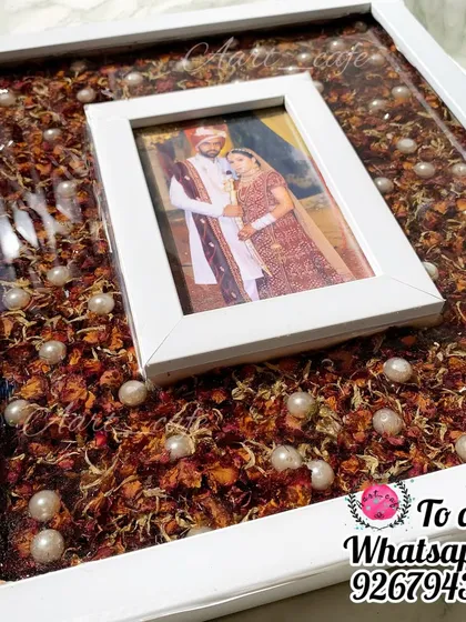 A closer look at the white floating photo frame, showing how the couple's picture seems to hover over the preserved varmala petals. It's a contemporary design for the modern couple.