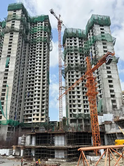 Construction progress on a large-scale residential township, showing the concrete shells of the towers rising against the skyline.