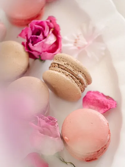 An ethereal, soft-focus shot of macarons and roses, using blur and light to create a dreamy, almost magical quality.
