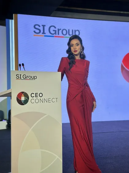 Posing by the lectern, this image shows the complete look for the corporate event host. The makeup is refined and professional, suitable for a high-profile business conference.
