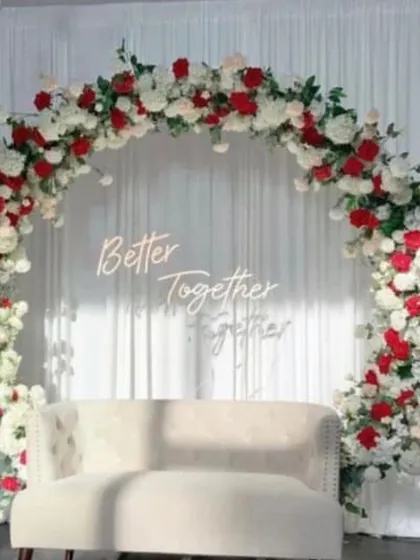 You can never go wrong with classic elegance. This beautiful circular arch, covered in lush red and white roses with a "Better Together" neon sign, creates a timeless and romantic backdrop for an anniversary or engagement celebration.