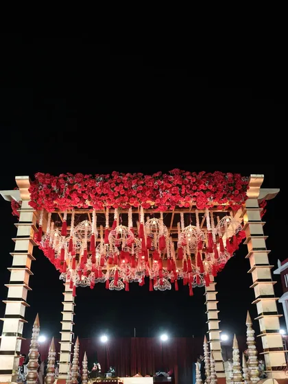 A detailed shot of the mandap's ceiling, covered in a dense layer of red roses with intricate, custom-made hangings that reflect our attention to detail.