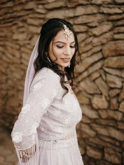 A close-up bridal portrait showing the bride's soft expression and elegant makeup. The focus is on her serene beauty on her special day.