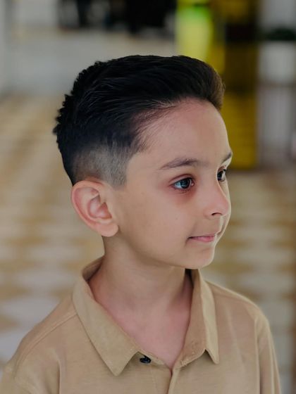 This side view shows the neat fade and clean lines of his new haircut, a style that's both smart and easy to manage.