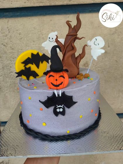 Adorably spooky. This Halloween-themed cake features cute ghosts, a spooky tree, bats, and a jack-o'-lantern, all handcrafted from fondant.