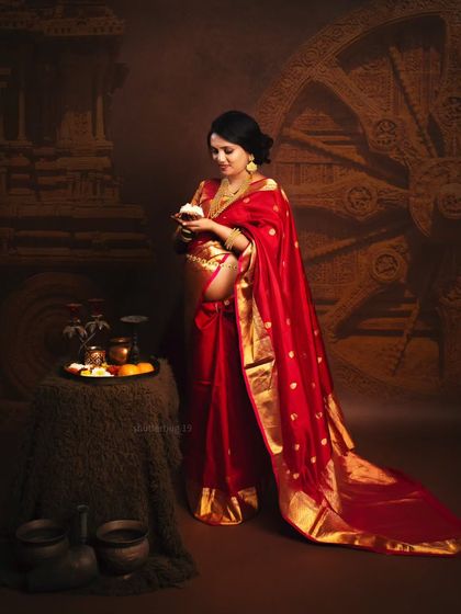 A slightly different pose from the traditional saree shoot, where the mom-to-be holds a small diya (lamp). This adds a spiritual and warm element to the overall composition.
