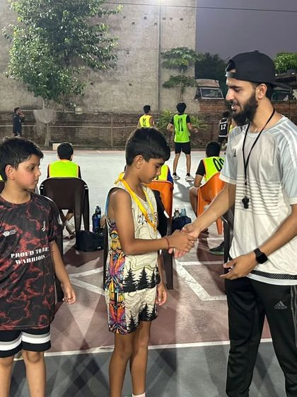 A handshake of respect and congratulations. I’m here awarding a medal to a player for his efforts in the U-10 basketball match in Gurugram.