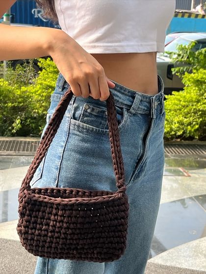 This is another look at the finished teddy brown crochet bag, styled for a day out. The tight stitches give it a solid structure, and the braided strap is both durable and comfortable.