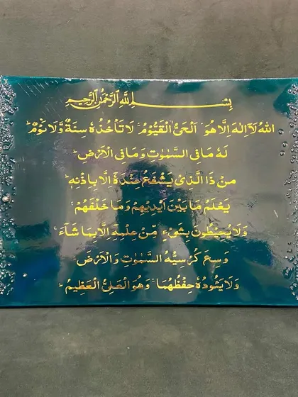 An elegant Ayat ul Kursi plaque in a rich emerald green and gold color scheme. The borders are adorned with a cascade of crystals and pearls, adding a touch of luxury to the sacred verse.