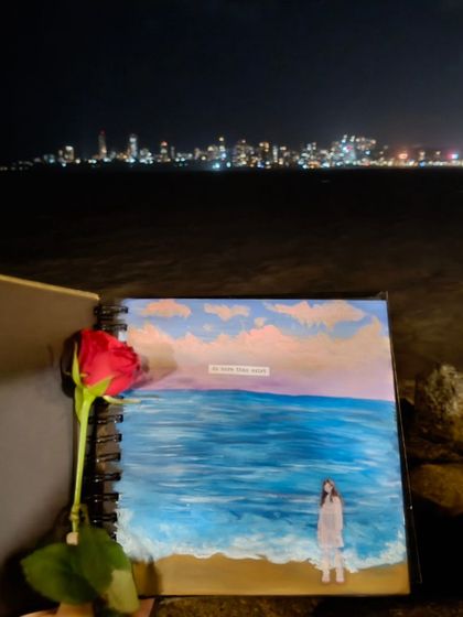 My sketchbook art displayed against the beautiful backdrop of the Mumbai skyline at night. The painting is a self-portrait on a beach, connecting my art to the city I love.