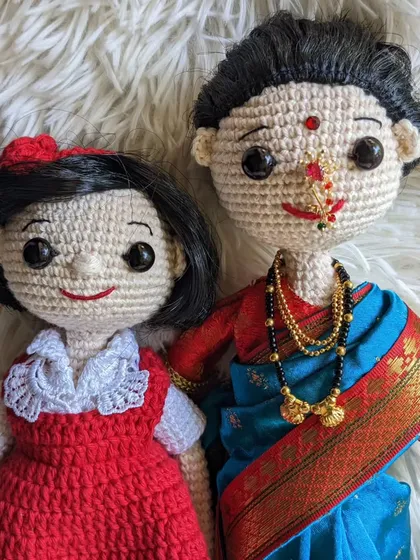 A detailed close-up of the faces on the mother-daughter crochet set.