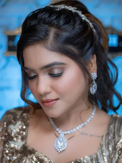 This angle shows the shimmering eyeshadow and the half-up ponytail hairstyle that completes this glamorous party look.