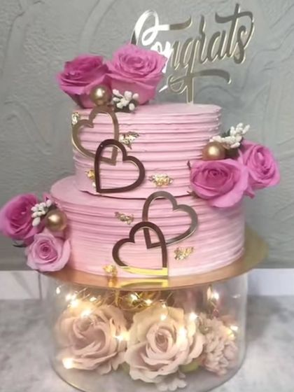 A gorgeous pink spacer cake with heart toppers, perfect for an engagement or anniversary.