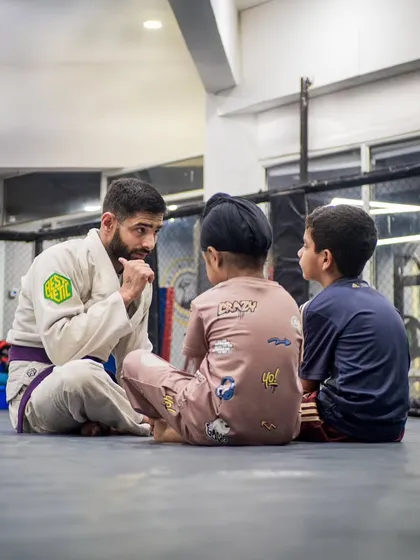 Mentorship is at the heart of what we do. Here, Coach Shaun takes the time to connect with our youngest students, explaining concepts and building the trust that is essential for real growth on and off the mats.