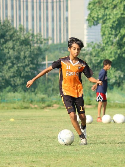 A young player dribbles with precision and focus during a training session. We encourage creativity and skill expression.