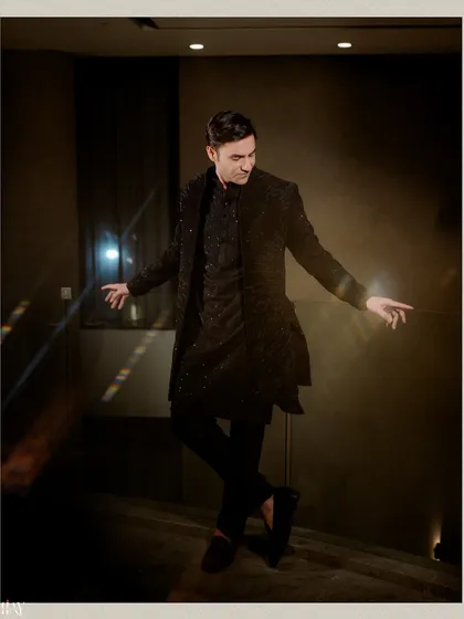 A dynamic and stylish portrait of the groom, captured mid-pose during his Sangeet night.