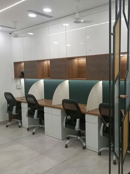 The completed workstation area for a CA firm, designed for focus and efficiency. The space features semi-private cubicles with acoustic paneling, ample overhead storage, and integrated task lighting for a clean and productive environment.