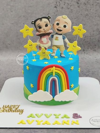 A Cocomelon cake for twins! This cheerful cake features the brother and sister from the show, along with a rainbow and bright yellow stars.