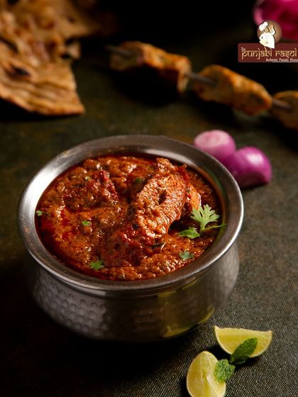 Indulge in the rich, creamy goodness of our signature gravy. This close-up shot of our chicken curry highlights the traditional texture and taste of Punjab.