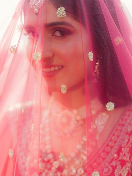 Another beautiful veil shot, capturing the bride's happy expression and the flawless finish of her makeup.
