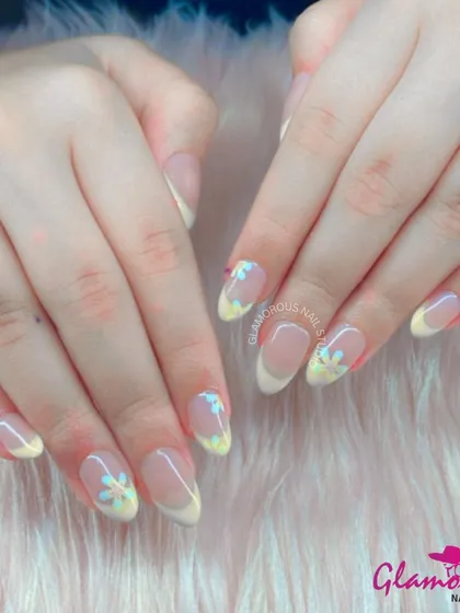 A soft and delicate floral French manicure. We used a pale, buttery yellow for the tips and added hand-painted daisies for a look that is fresh, pretty, and perfect for spring.