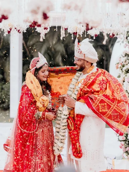 A beautiful moment from a daytime Odia wedding ceremony. As flower petals rain down, the couple shares a look of love and understanding. The soft winter sunlight adds a magical glow to this sacred ritual.