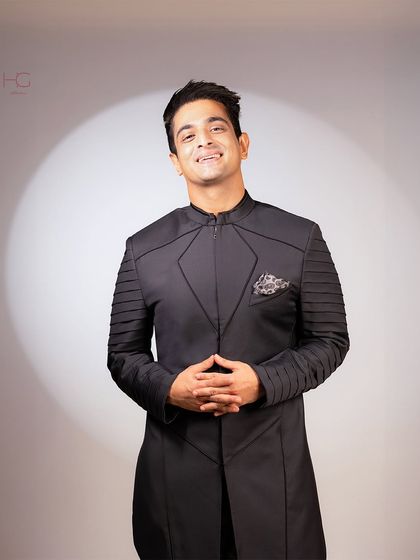 A closer look at the superhero-inspired achkan, showing the pocket square detail and the precise fit across the shoulders and chest.