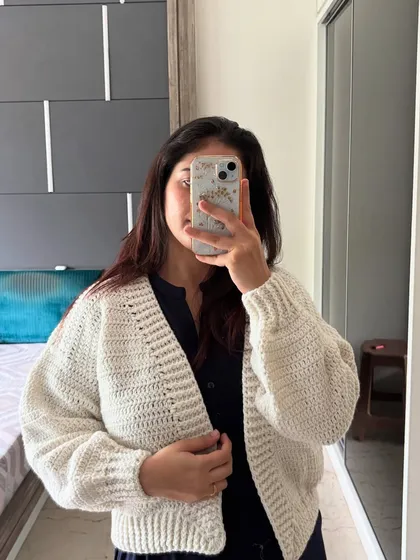 Our Plum Puff Cardigan in a classic white. This handmade crochet sweater is incredibly versatile and features our signature puff sleeves for a fashionable, cozy fit.