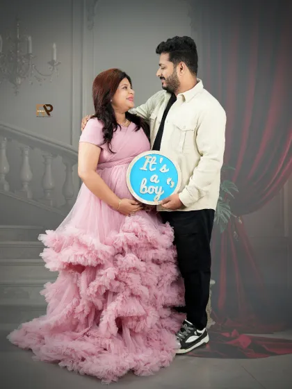 Announcing "It's a boy!" in style. This couple's portrait uses a prop to share their exciting news, with the mom-to-be looking radiant in a pink ruffled gown.
