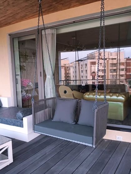 A stylish and modern swing adds a relaxing element to this balcony, which features composite decking and a built-in sofa.