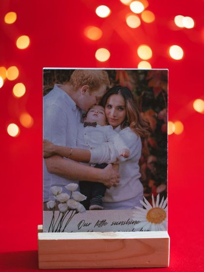 A family photo displayed on a custom wooden stand with the caption "Our little sunshine." These stands are a beautiful way to display treasured family moments.