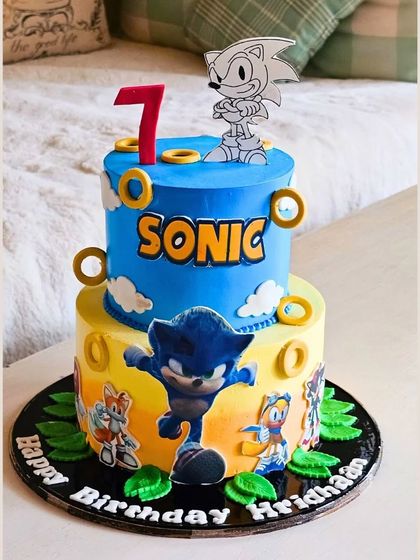 A speedy two-tier Sonic the Hedgehog cake, capturing the energy of the game with gold rings and character illustrations.