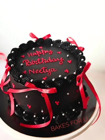 A dramatic black version of the ribbon cake, with red lettering and silver pearls. The contrast between the black, red, and white creates a bold and elegant statement.