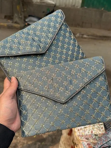A pair of elegant envelope-style clutches with a quilted gold embroidery pattern. These are perfect for a formal dinner or event.