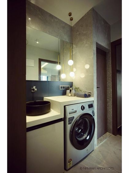We reconfigured the layout in this home to create a dedicated utility area with a washing machine and a stylish powder room. The design features a modern black basin and elegant pendant lighting.