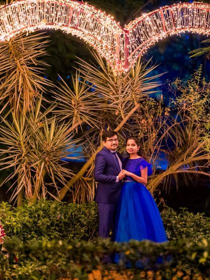 The large, illuminated heart prop provides a grand and romantic frame for this couple's night-time portrait.