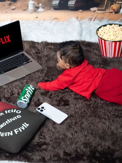 The perfect 'Netflix and Chill' setup for a baby. This little one is catching up on his favorite shows with popcorn and a soft drink.