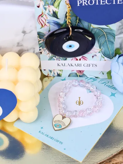 A variation of our evil eye Rakhi hamper, this one featuring a sparkle bracelet Rakhi with an evil eye heart charm.