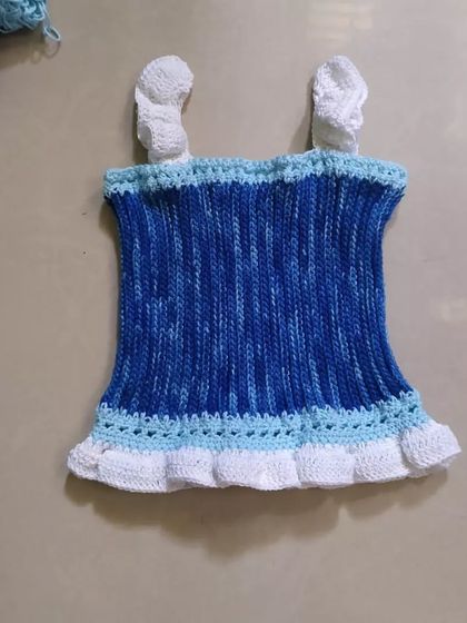 This is the Cotton Candy Dream Top before it was modeled. The variegated blue yarn creates a beautiful effect, complemented by the white ruffled trim and straps.