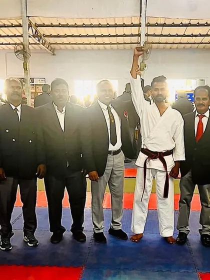 My hand raised by the officials after a successful bout. Competing keeps my skills sharp and my spirit strong, and I bring that fire back to my students.