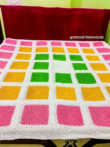A closer look at the texture and stitch work of the colorful granny square bedspread. Each piece is tightly woven to ensure it is warm and long-lasting.